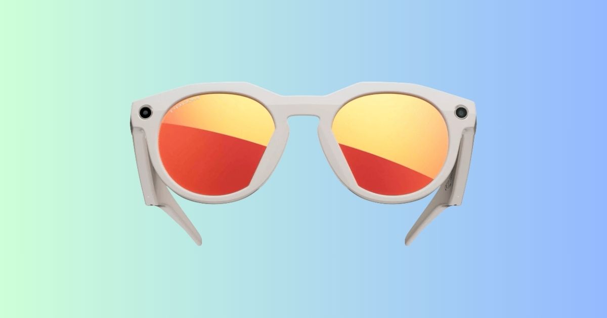 Oakley Meta HSTN smart glasses with orange reflective lenses on a pastel green to blue gradient background