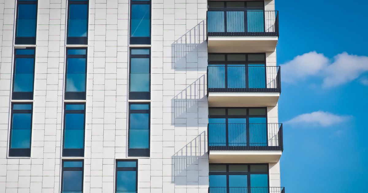 Modern apartment building with balconies, ideal for passive income real estate through rental investments.